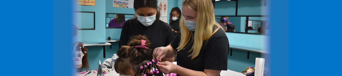 Cosmetology students practice perming hair