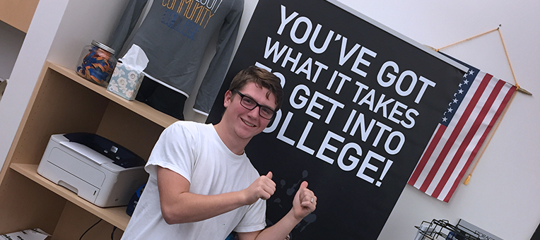 A teenage boy completes his application for college.