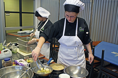 Two female Catering & Culinary Management students prepare a dish in preparation for competition.
