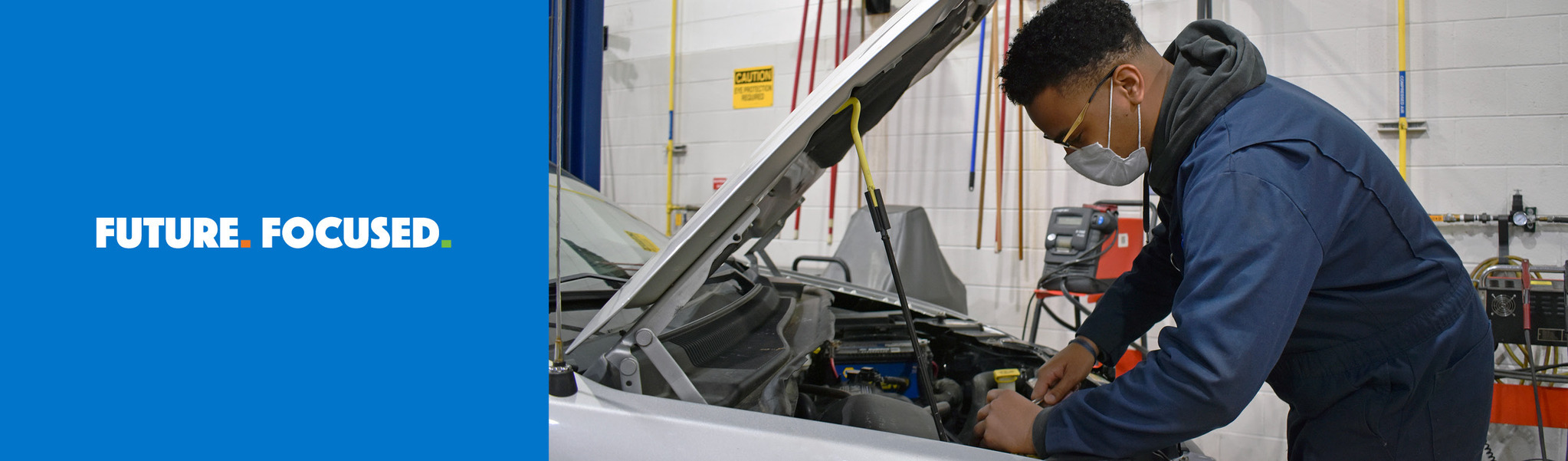 Auto Service Technology student looking under the hood of a vehicle