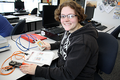 A female Internet, Network & Security Technologies student works on making cables for a wired network.