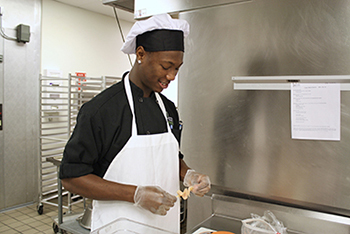 Culinary student preparing food.