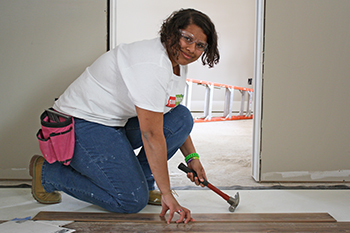 Contruction Trades student installing wood flooring.