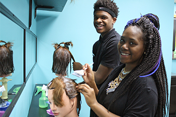 Cosmetology photo of students working on manikins.