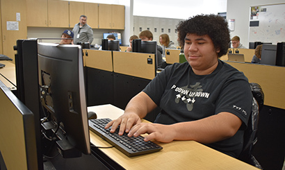 A student types code into his computer