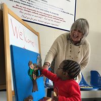 Child and teacher retelling a story on an easel with velcro story pieces. 