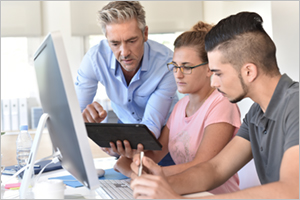 Employee assigning intern students task at the computer