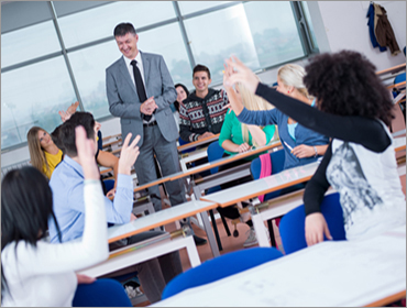 Business man talking to group of students