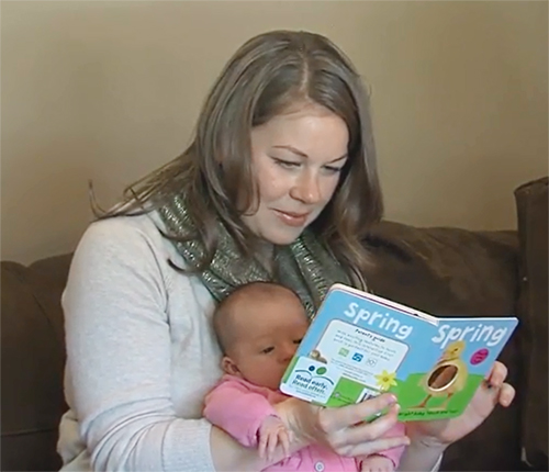 Mom reading book to infant