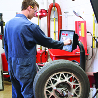 Male student in Auto Service program with large tire