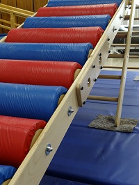 Occupational Therapy climbing equipment, consisting of a ladder of multi-colored foam rollers